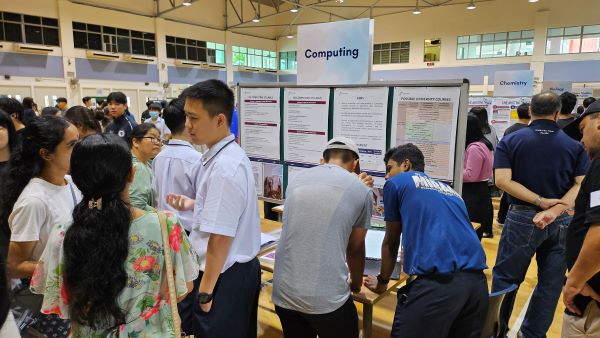 Students engaging visitors at the Computing booth